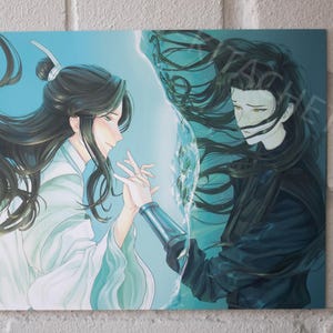 May include: An art print featuring two figures with long, dark hair, holding hands. One figure wears white robes, the other dark clothing. The background is a gradient of blue and white, with a dividing element between the figures.