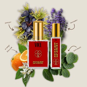 May include: Two glass perfume bottles with gold caps and red labels featuring the text VICE and ES'SAINT. The bottles are surrounded by illustrations of juniper berries, lavender sprigs, orange blossoms, and patchouli leaves with labels.