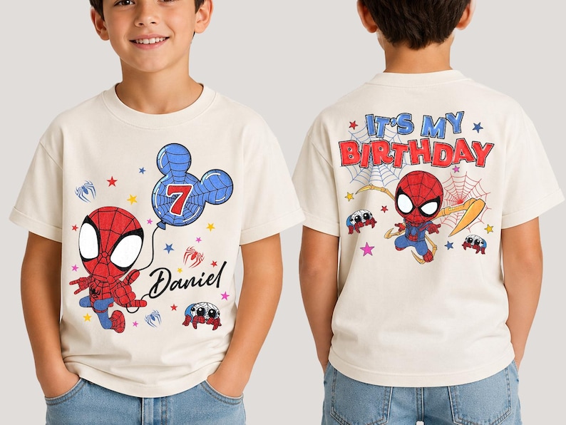 May include: A cream-colored short-sleeve t-shirt featuring a graphic of a red and blue superhero character holding a balloon shaped like a mouse head with the number 7 and the name Daniel. The back displays the text IT'S MY BIRTHDAY.