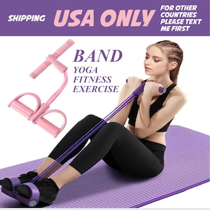 Puede incluir: Una mujer utiliza una banda de resistencia rosa y morada para yoga y ejercicios de fitness. La banda tiene pedales y asas. El texto de la imagen dice "USA ONLY" y "BAND YOGA FITNESS EXERCISE".