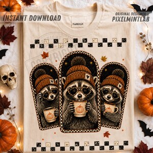 Może przedstawiać: Kremowy t-shirt z grafiką przedstawiającą trzy szopy pracze w pomarańczowych czapkach z dzianiny i okularach w kształcie serc. Każdy szop trzyma kubek z ilustracją dyni. Wzór jest otoczony łukami i czarno-białym wzorem w szachownicę.