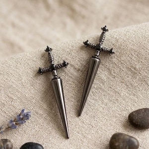 Puede incluir: Un juego de tres tazas de cerámica con un acabado mate moteado. Las tazas son en tonos crema, gris claro y gris oscuro. Cada taza tiene un diseño simple y minimalista, ideal para café o té.