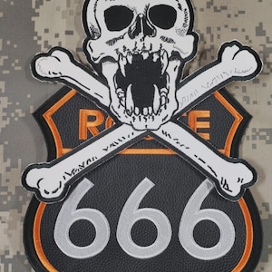 May include: A black and orange Route 666 patch featuring a skull with crossed bones. The skull is white with black eye sockets and an open mouth. The number 666 is in silver, and the patch has a black background.