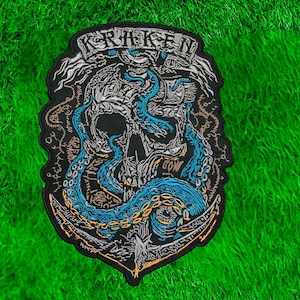 Könnte beinhalten: Gestickter Aufnäher mit einem Totenkopf, blauen Tentakeln, einem Anker und dem Wort "KRAKEN" in einem Banner. Das Design ist in Schwarz, Weiß und Blau gehalten, mit goldenen Akzenten. Der Aufnäher hat einen schwarzen Rand auf grünem Grund.