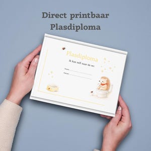 May include: A white certificate with the text "Plasdiploma" and a cartoon hedgehog on a toilet. The certificate has a gold border and is held by two hands against a blue background. The text "Direct printbaar Plasdiploma" is at the top.