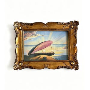 May include: A painting in a gold ornate frame shows a pearl emerging from a seashell on a beach at sunset. The shell is pink and grey, with a bright pearl. The sky is a mix of blue, yellow, and pink. The frame has decorative details.