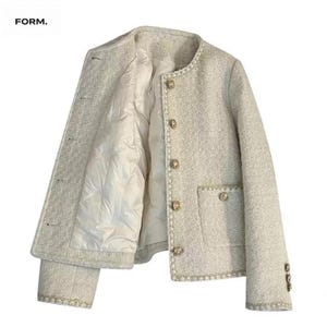 Puede incluir: Chaqueta de tweed de color claro con botones y ribetes dorados. La chaqueta tiene cuello redondo, forro acolchado y un bolsillo en la parte delantera. La palabra "FORM." está en la esquina superior izquierda.