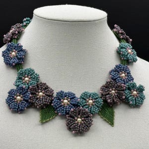 Puede incluir: Un juego de tres tazas de cerámica con un acabado mate moteado. Las tazas son de color crema, gris claro y gris oscuro. Cada taza tiene un diseño simple y minimalista.