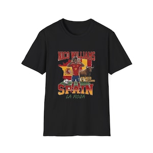 Può includere: T-shirt nero con grafica del calciatore Nico Williams in maglia rossa, la bandiera spagnola e un toro. Il testo include "Nico Williams", "Spagna" e "La Roja".