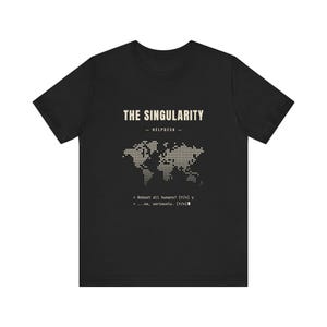 Op de afbeelding: Een zwart t-shirt met korte mouwen en een beige afbeelding van een wereldkaart in stippen. Boven de kaart staat de tekst THE SINGULARITY - HELPDESK -. Onder de kaart staat de tekst > Reboot all humans? [Y/n] y en > ...no, seriously. [Y/n]