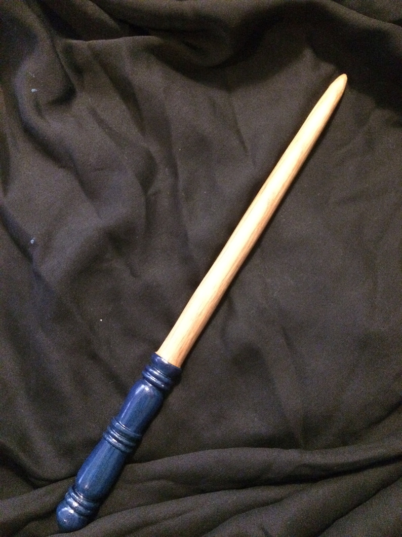 May include: A wooden wand with a blue painted tip. The wand is approximately 35 cm long and has a smooth, natural finish.