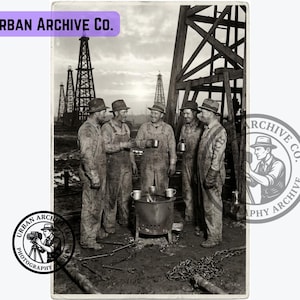Op de afbeelding: Een zwart-witfoto getiteld Urban Archive Co. met vijf arbeiders in overalls en hoeden die rond een kleine metalen vuurkorf met mokken staan. Op de achtergrond staan verschillende hoge boortorens tegen een bewolkte lucht. Een cirkelvormig logo met een persoon die een camera vasthoudt, is zichtbaar in de linkerbenedenhoek.