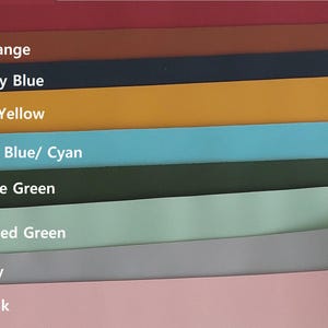 May include: A colour palette showing nine swatches in a gradient of hues. The colours include brick red, burnt orange, dark navy blue, mustard yellow, light sky blue/cyan, dark olive green, light muted green, light grey, and dusty pink.