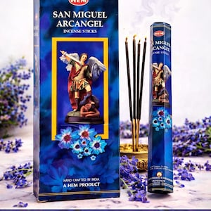 Puede incluir: Una caja azul y un envase cilíndrico de varillas de incienso San Miguel Arcángel. La caja presenta una imagen de un ángel con una espada, una estatua y flores azules. El texto dice "Protección Fe Energía Positiva".