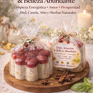 Puede incluir: Dos jabones en envases transparentes, uno en forma de flor y otro rectangular, con el texto "Dulce Atracción & Belleza Abundante". Los jabones están sobre una bandeja de madera con palitos de canela y anís estrellado.