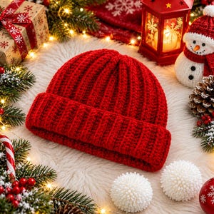 May include: A vibrant red, ribbed knit beanie hat featuring a thick, folded cuff. The hat is crafted with a textured, vertical stitch pattern throughout, providing a classic look. The deep red color is consistent across the entire surface of the beanie.