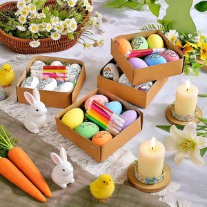Può includere: Composizione a tema pasquale con uova decorate, pennarelli e materiali per l'artigianato in scatole di cartone. Coniglietti di ceramica bianchi, pulcini gialli e carote sono sparsi. Candele accese e un cesto di fiori bianchi completano la scena.