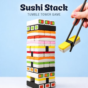 Könnte beinhalten: Ein Sushi Stack Tumble Tower Spiel mit einem vertikalen Turm aus rechteckigen, sushi-förmigen Blöcken in Weiß, Schwarz, Orange, Gelb, Pink und Grün. Ein schwarzes Stäbchenpaar hält ein gelb-weißes Sushi-Blockstück an der Seite.