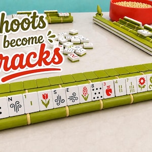 Puede incluir: Un conjunto de soportes de juego estilo bamb&uacute; verde y fichas blancas con s&iacute;mbolos florales, de viento y num&eacute;ricos coloridos. El texto "Shoots become racks" aparece en una fuente estilizada verde y roja. Se ve un cuenco rojo con fichas beige.