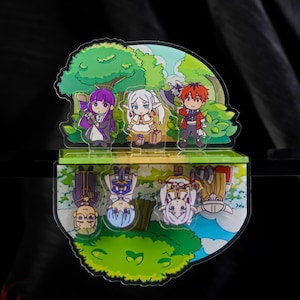 Puede incluir: Un colorido soporte acrílico con tres personajes de dibujos animados en un entorno forestal. El soporte tiene una base espejada, que refleja los personajes y el paisaje. Los personajes tienen pelo morado, blanco y rojo, y visten varios atuendos.