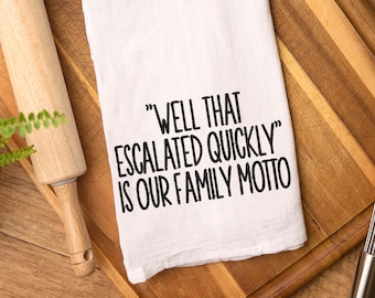 Może przedstawiać: Biały ręcznik kuchenny z czarnym tekstem, który brzmi "Well that escalated quickly is our family motto".