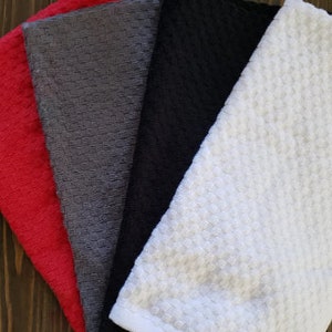 May include: Four waffle weave kitchen towels in red, gray, black, and white. The towels are 28 inches by 16 inches.