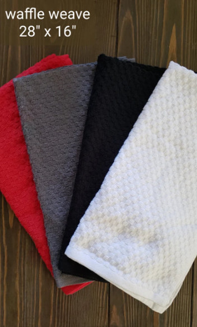 May include: Four waffle weave kitchen towels in red, gray, black, and white. The towels are 28 inches by 16 inches.
