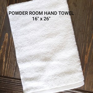 May include: White hand towel with the text "POWDER ROOM HAND TOWEL 16" x 26""
