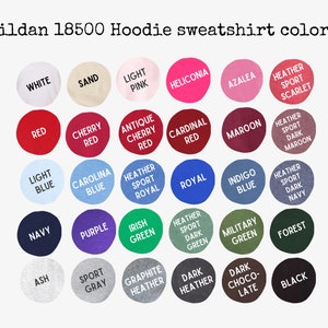 May include: A color chart for Gildan 18500 hoodie sweatshirts featuring thirty circular swatches in various shades including white, sand, pink, red, blue, green, gray, brown, and black, each labeled with its corresponding color name in black text.