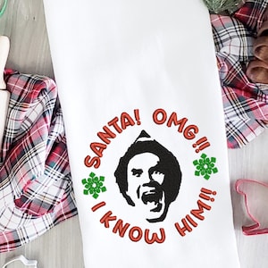 May include: White kitchen towel with red embroidered text that reads "Santa! OMG!! I Know Him!!" and a black silhouette of a man wearing a Santa hat with a surprised expression.