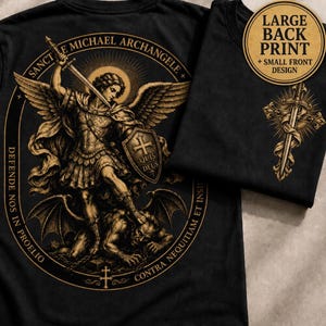 Op de afbeelding: Een zwart t-shirt met een grote achterprint van de aartsengel Michaël die een demon verslaat, omringd door de tekst 'SANCTE MICHAEL ARCHANGELE DEFENDE NOS IN PROELIO CONTRA NEQUITIAM ET INSIDIAS'. De voorzijde heeft een klein zwaardontwerp.
