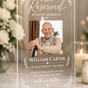 Könnte beinhalten: Ein Gedenkschild aus klarem Acryl mit rechteckigem Sockel und dem Porträt eines älteren Mannes. Der Text lautet: A SEAT Reserved IN LOVING MEMORY OF WILLIAM CARTER GRANDFATHER OF THE BRIDE THOUGH WE CANNOT SEE YOU, WE KNOW YOU ARE HERE with us today.