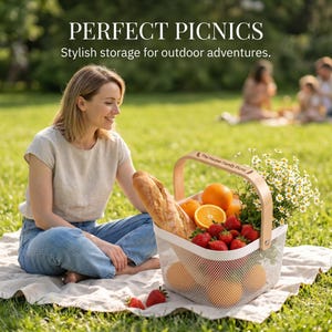Pu&ograve; includere: Un cestino da picnic pieno di frutta fresca, una baguette e fiori. Il cestino ha un manico in legno e un corpo in rete bianca. Il testo "PERFECT PICNICS" &egrave; nella parte superiore dell'immagine.