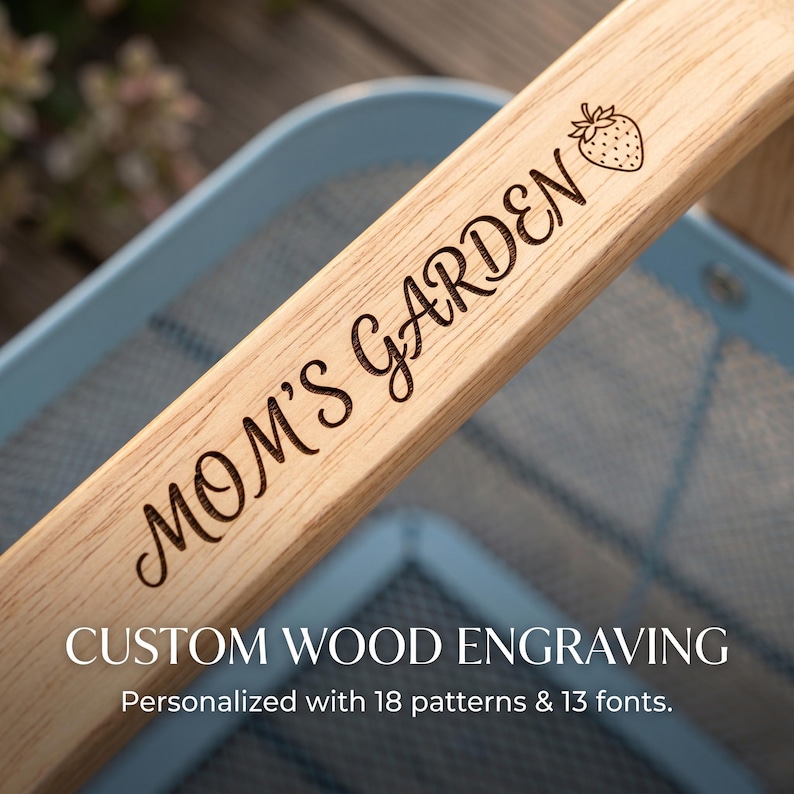 Pu&ograve; includere: Primo piano di un manico in legno chiaro con la scritta incisa "MOM'S GARDEN" e un'illustrazione di fragola. Il manico fa parte di un cesto da giardino. Il testo "CUSTOM WOOD ENGRAVING" &egrave; sotto.