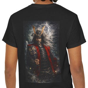 Puede incluir: Camiseta negra con un gráfico detallado de un guerrero samurái con pelo blanco largo, una chaqueta roja y un casco con cuernos. La obra de arte está ambientada sobre un fondo de relámpagos y un cielo nublado, creando un efecto dramático.