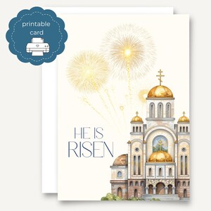 May include: A printable Easter card featuring a watercolor illustration of a church with gold domes and fireworks. The words "HE IS RISEN" are written in navy blue. A blue scalloped circle with a printer icon is in the upper left corner.