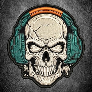 May include: An embroidered patch featuring a detailed off-white human skull wearing teal headphones with a bright orange headband. The design is outlined in black thread, showcasing intricate stitching that highlights the skull's cracks and features.