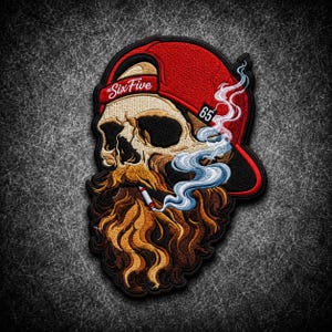 May include: An embroidered patch featuring a skull with a long, flowing brown beard, wearing a red baseball cap with the text "The Six Five" and the number "65". The skull is smoking a cigarette, with blue and white smoke swirling upwards.