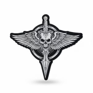 May include: A black and white embroidered patch featuring a skull with wings, a sword, and a circular emblem. The skull is centered, with wings extending outward. The design is detailed and intricate, suitable for jackets or bags.