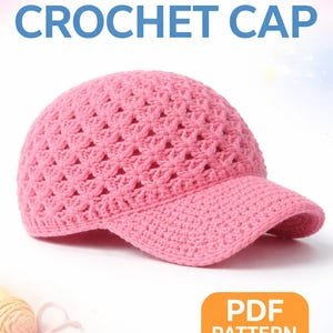 Peut inclure: Casquette rose en crochet avec visière. Le chapeau est fait d'un point texturé à tissage ouvert. Les mots "Cute CROCHET CAP" sont écrits en rose et bleu. Les mots "PDF PATTERN" sont dans un encadré orange.