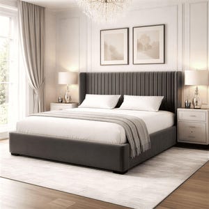 May include: A grey upholstered bed with a tall, vertically-lined headboard. The bed is made up with white bedding and a grey throw blanket. Two white bedside tables with lamps flank the bed. The room has a chandelier and framed artwork.