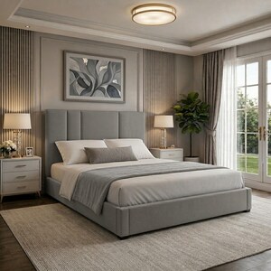 May include: A contemporary bedroom with a grey upholstered bed, tall headboard, white bedding, and a grey throw. Two bedside tables with lamps are either side of the bed. A grey rug and artwork complete the neutral colour scheme.