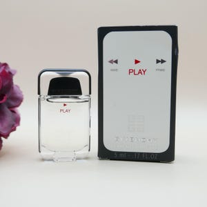 May include: A clear glass bottle of Givenchy Play eau de toilette with a silver cap and red text, accompanied by its rectangular black and white box featuring media player icons, the word PLAY, and a volume of 5 ml .17 FL.OZ printed on the front.