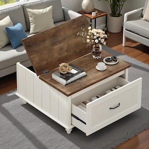 May include: A white and brown lift-top coffee table with a drawer. The tabletop is brown, and the base is white with vertical paneling. The drawer is open, revealing its contents. A vase of flowers, books, and decorative items are on the table.