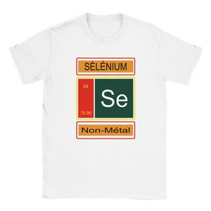 May include: A white short-sleeve t-shirt featuring a graphic of the chemical element Selenium. The design includes the text SÉLÉNIUM, the atomic number 34, the symbol Se, the atomic weight 78.96, and the text Non-Métal in a rectangular layout.