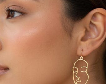 Pendientes de alambre con rostro abstracto dorado – Joyería minimalista con diseño lineal