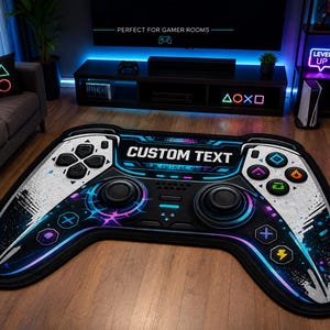 Puede incluir: Una alfombra grande con forma de mando de videojuego con un esquema de colores negro, blanco y azul. La alfombra presenta el texto CUSTOM TEXT en el centro, junto con varios botones circulares y geométricos, joysticks y detalles de neón.