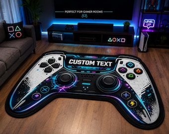 May include: A large area rug shaped like a video game controller featuring a black and white color scheme with blue, purple, and yellow accents. The center of the rug displays the text CUSTOM TEXT in white letters surrounded by gaming icons.