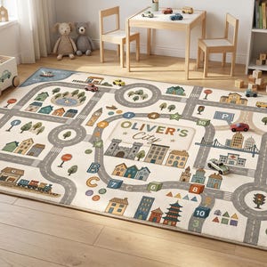 Könnte beinhalten: Ein rechteckiger Teppich mit einem aufgedruckten Stadtplan-Design, das Straßen, Gebäude, Bäume und eine Eisenbahnstrecke zeigt. In der Mitte steht der Text OLIVER'S City. Der Teppich enthält bunte Illustrationen von Häusern, einer Burg und Zahlen.