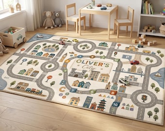 May include: A rectangular area rug featuring a printed city map design with roads, buildings, trees, and the text "OLIVER'S City" in the center. The rug includes illustrations of a castle, houses, a train, and numbered blocks on a light background.